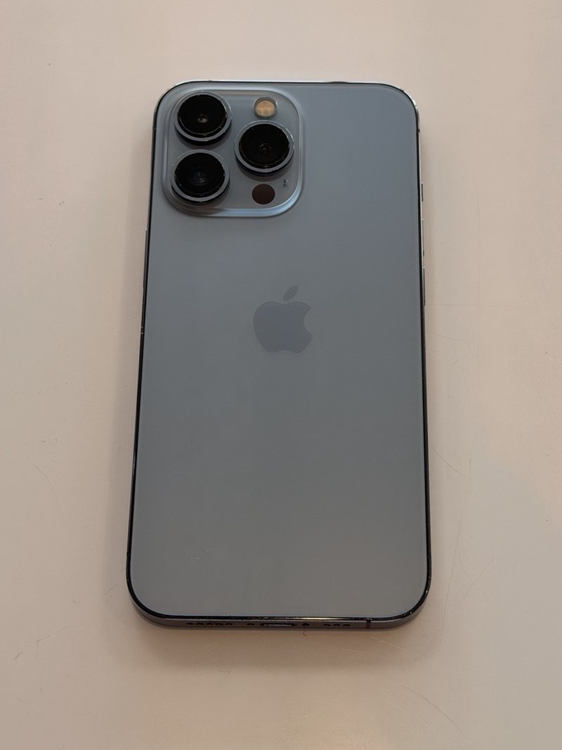 The same blue phone after rear glass replacement, with an intact undamaged panel.